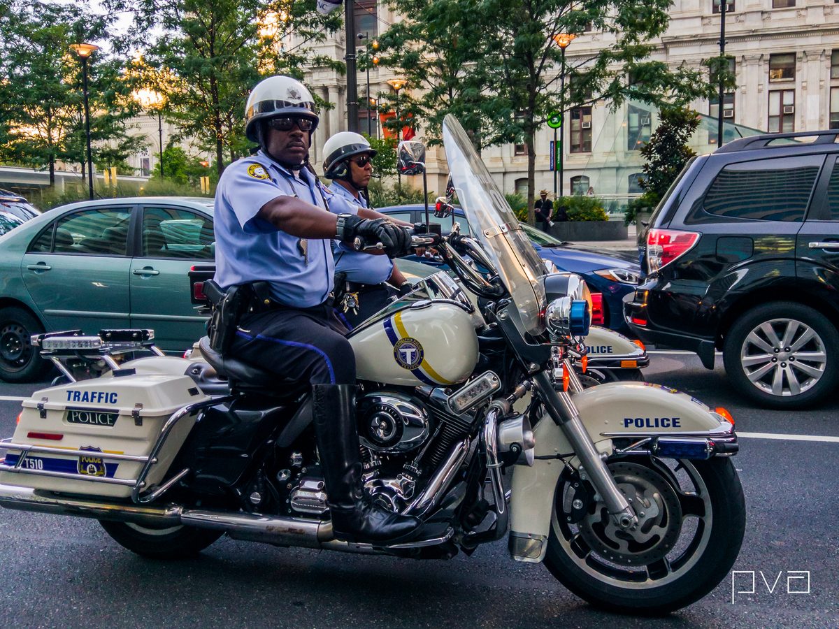 Two traffic police on motorcycles waiting in the road by City Hall in the evening.