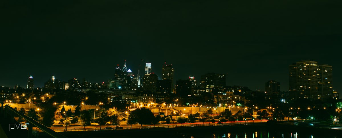 The Philadelphia skyline at night across the parkway, a long low panorama of lit towers.