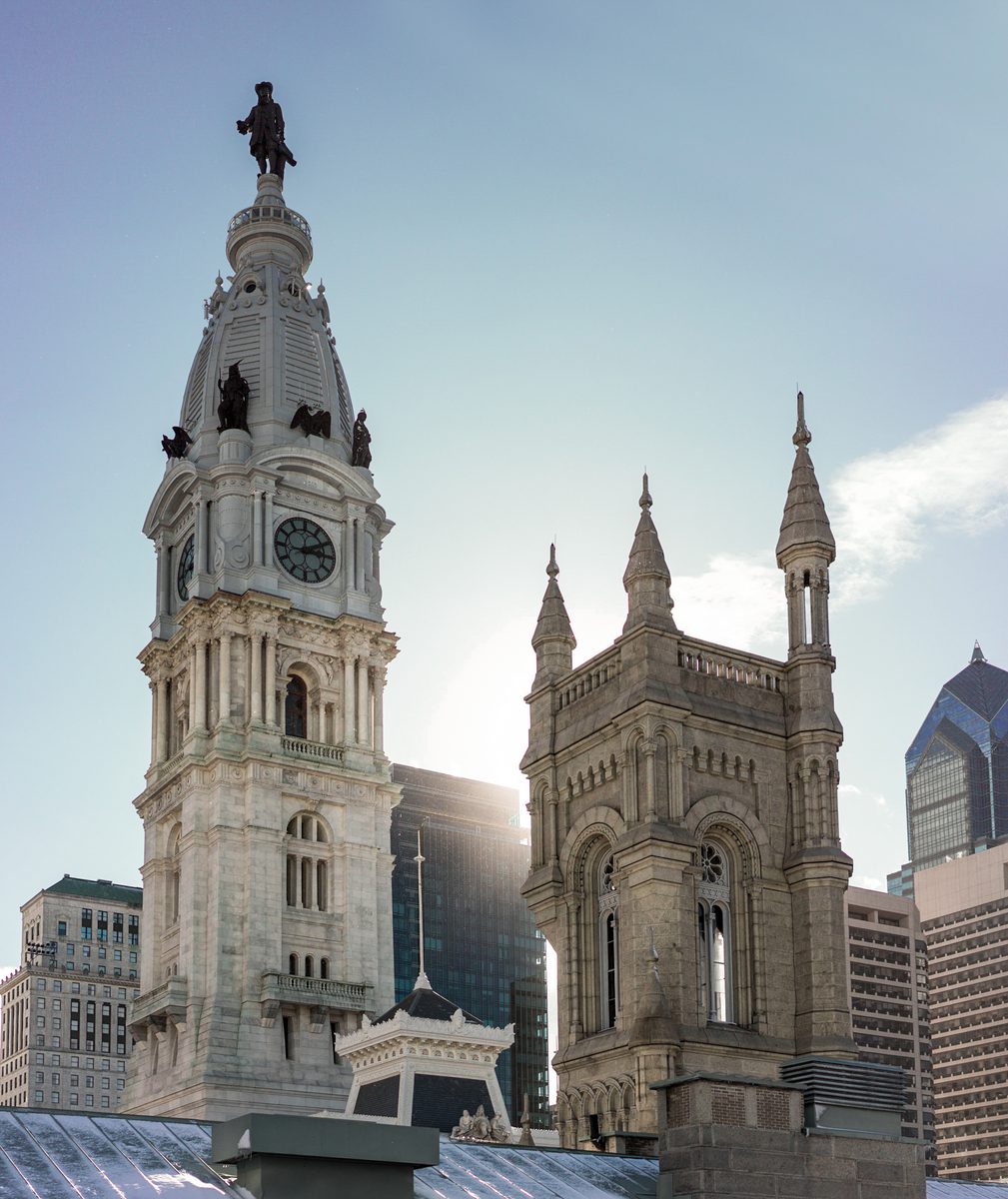 The tower of City Hall and the spires of the Masonic Temple against a bright winter sky.